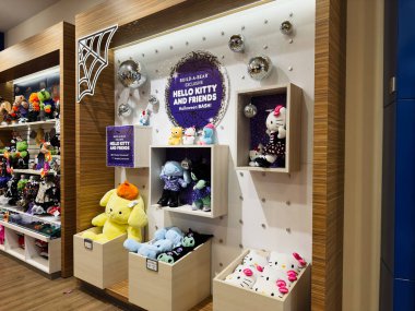 Manchester, İngiltere - 26 Eylül 2025: Parlak bir oyuncak atölyesinde sezonluk sergi için ahşap raflarda dizilmiş renkli pelüş karakterler.