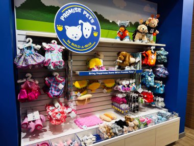 Manchester, İngiltere - 26 Eylül 2025: Parlak pelüş oyuncaklar ve kıyafetler renkli bir evcil hayvan atölyesinde sergileniyor Oyuncak aile alışverişine davet ediliyor.