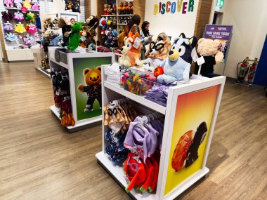 Manchester, İngiltere - 26 Eylül 2025: Dolgun ayılar, doldurulmuş hayvanlar, giyim bölümleri ve parlak ekranlı canlı oyuncakçı sahnesi.