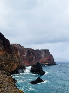Madeira 'nın engebeli kıyıları boyunca yükselen uçurumlar, karanlık kayalar ve turkuaz sularla dramatik bir deniz manzarası. Saint Lawrence Noktası
