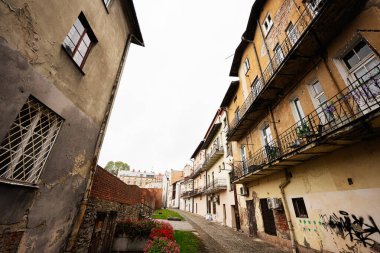 Tarnow, Polonya - 10 Ekim 2025: Tarnow Polonya 'da tuğla duvarlar, balkonlar, çiçekler ve kentsel dokuların yer aldığı tarihi bir ara sokak.