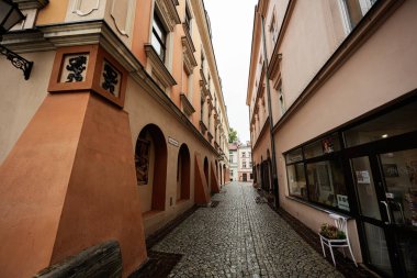 Tarnow, Polonya - 10 Ekim 2025 Tarnow Polonya 'da kemerler, sıcak pastel cepheler ve mağazalarla dolu dar bir patika..