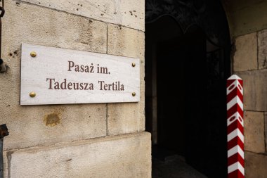 Tarnow, Polonya - 10 Ekim 2025: Tarnow, Polonya 'da Tadeusz Tertila' nın adını taşıyan plaket işlemeli bir geçitli taş duvar.
