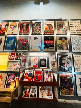 Lizbon, Portekiz - 28 Eylül 2025: Lizbon 'daki bir galeride çerçevelenmiş posterler ve sanat eserleriyle dolu parlak duvar.