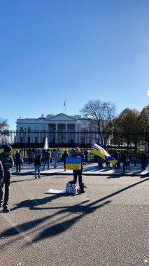 Washington, DC, ABD - 22 Kasım 2023: Washington DC 'deki Beyaz Saray' ın önünde işaretler ve Ukrayna bayrağıyla toplanan kalabalık eylemciliği ifade ediyor.
