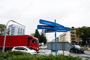 Tarnow, Polonya - 10 Ekim 2025: Tarnow, Polonya 'da mavi yön işaretleri, trafik ve şehir binaları olan şehir manzarası.