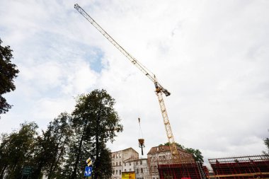 Tarnow, Polonya - 10 Ekim 2025: Tarnow 'daki inşaat sahasında kısmen inşa edilmiş bir yapının yanında vinç kaldırma malzemeleri görülüyor.