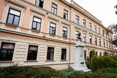 Tarnow, Polonya - 10 Ekim 2025: Tarnow Polonya 'da Kazimierz Brodzinski büst heykeli ve manikürlü bahçenin yer aldığı tarihi bina