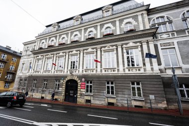 Tarnow, Polonya - 10 Ekim 2025: Tarnow şehir merkezindeki büyük bina, dışarıda bayraklar sergileniyor, tarihi mimariyi yansıtıyor..