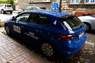 Tarnow, Polonya - 10 Ekim 2025: Tuğla binaların yanında Tarnow Polonya 'da bir şehir caddesinde öğrenci tabelasıyla mavi sürüş okulu.