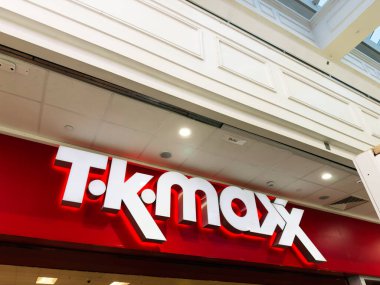 Manchester, İngiltere - 26 Eylül 2025: Cesur TK Maxx logosu bir alışveriş merkezinin içindeki kırmızı bir mağaza vitrininde davetkar bir perakende atmosferi yaratıyor.