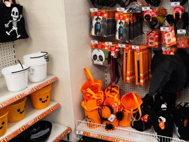 Manchester, İngiltere - 26 Eylül 2025: Parlak turuncu kovalar, kafatası izleri ve çeşitli kostüm aksesuarlarıyla bir Cadılar Bayramı mağazası sahnesi.