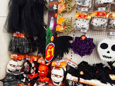 Manchester, İngiltere - 26 Eylül 2025: Ürkütücü Cadılar Bayramı gösterisi Bir mağaza tahtasındaki maskeler, kafatasları, balkabakları, yarasalar ve örümcek ağı süslemeleri.