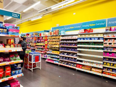 Manchester, İngiltere - 26 Eylül 2025: Müşteriler, değer odaklı bir pazarda parlak ışık altında renkli yiyecek raflarını keşfediyorlar