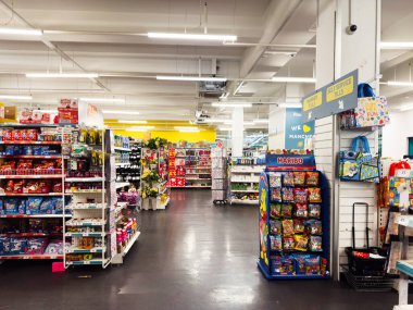 Manchester, İngiltere - 26 Eylül 2025: Atıştırmalık reyonları, şekerleme vitrinleri ve kasanın yanında bir Haribo standı olan yoğun mağaza sahnesi.