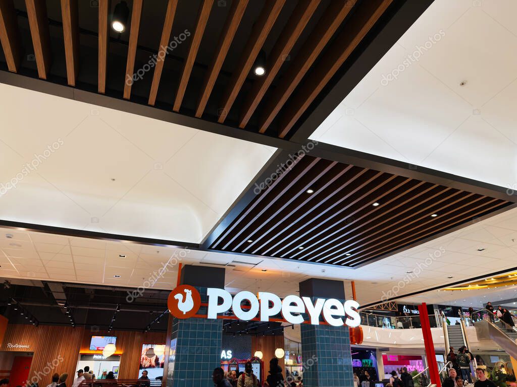 Manchester, UK - September 26, 2025: Vibrant Popeyes interior inside a mall, busy shoppers and modern lighting create an energetic dining atmosphere.