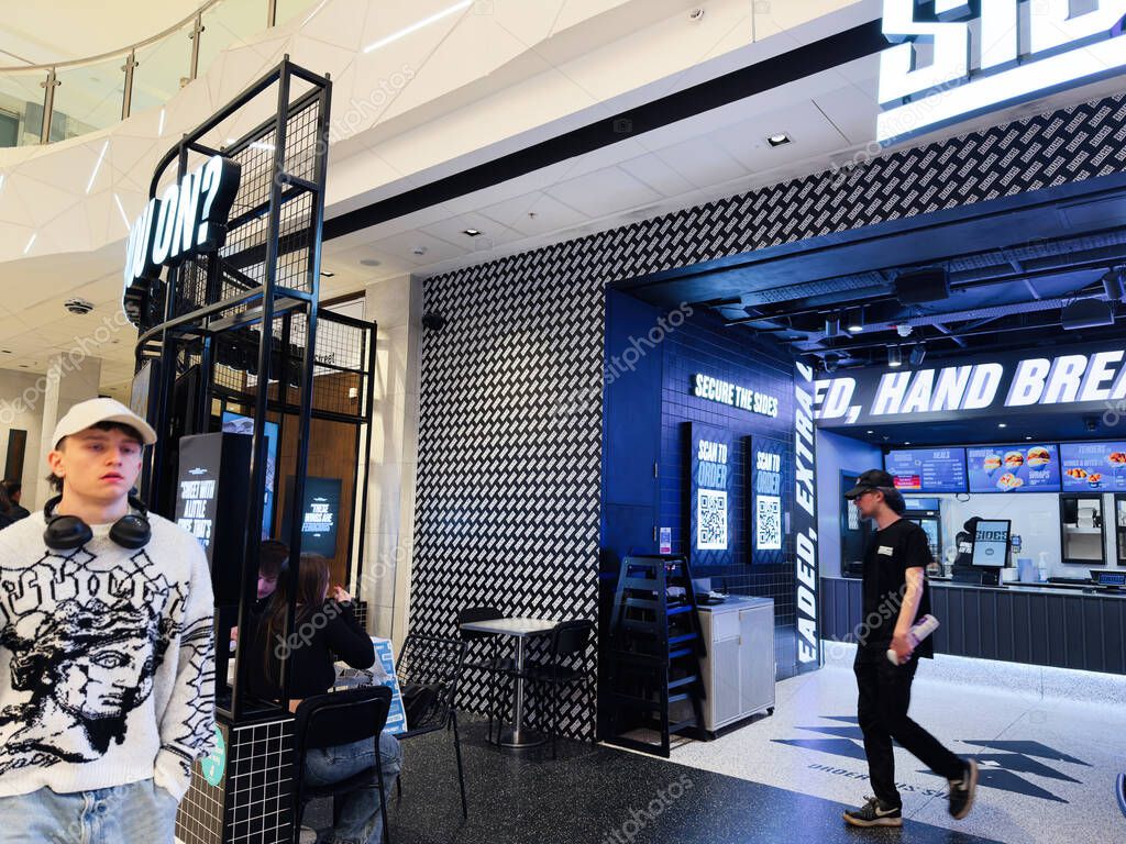Manchester, UK - September 26, 2025: A lively mall scene with a modern food court, customers and staff at Sides sleek counter.