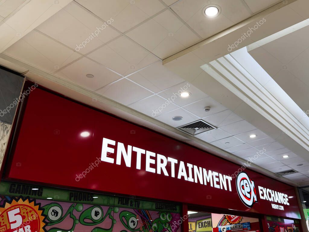 Manchester, UK - September 26, 2025: Bright red entertainment exchange storefront inside a shopping mall featuring game exchange branding and ceiling lights.