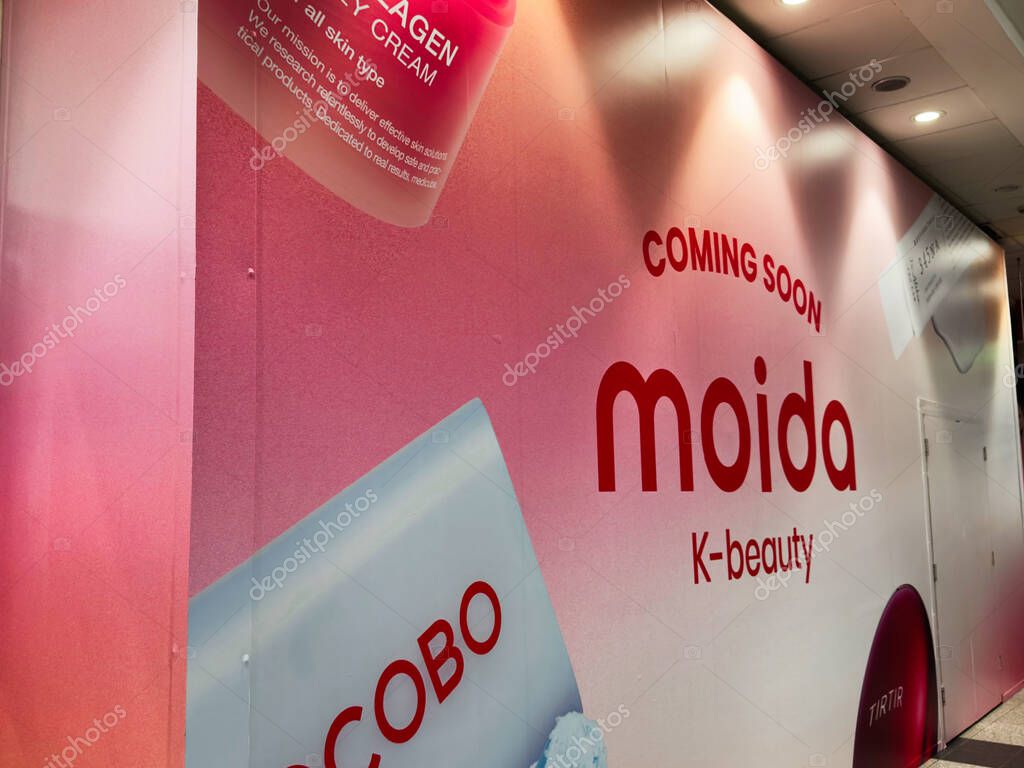 Manchester, UK - September 26, 2025: Pink corridor wall displays coming soon moida branding with bold red typography and beauty imagery