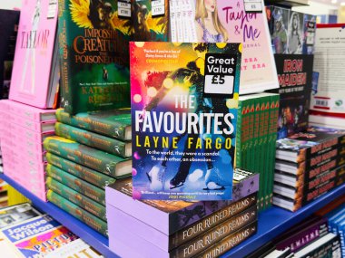 Manchester, İngiltere - 26 Eylül 2025: The Favourites by Layne Fargo, parlak raflardaki diğer romanlarla çevrili renkli bir kitapçıda sergilenmektedir.