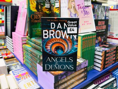 Manchester, İngiltere - 26 Eylül 2025: Dan Brown, Angels Demons, renkli bir kitapçının diğer başlıklarıyla birlikte kitap kapağı.