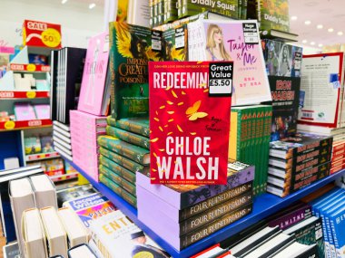 Manchester, İngiltere - 26 Eylül 2025: Chloe Walsh tarafından kurtarılan 6 kitap birçok roman arasında kalabalık bir kitapçıda sergilendi.