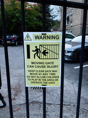 Manchester 'daki hareket halindeki kapıya uyarı işareti. Girişteki yaralanma riskini ve güvenlik yönergelerini vurguluyor..