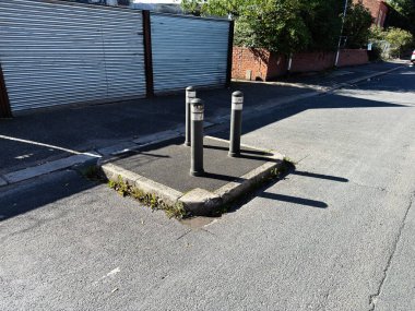 Sessiz bir Manchester caddesinde, bir duvar yazısının yanında yükseltilmiş beton bir platformda üç kalın kalıntı var..