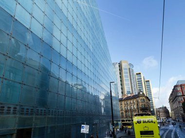 Manchester, İngiltere - 29 Eylül 2025: Modern bir Ulusal Futbol Müzesi cam cephesi yayalar ve parlak bir Slice otobüsüyle Manchester Todd caddesine hakim oldu.