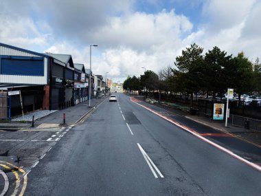 Manchester, İngiltere - 29 Eylül 2025: Manchester 'daki Urban Langston sokak sahnesinde mağazalar, beyaz bir araba ve yol boyunca ağaçlar yer aldı.