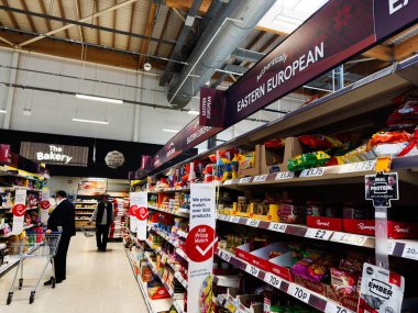 Manchester, İngiltere - 29 Eylül 2025: Fırın alanı ve uluslararası ürün tabelaları ile Manchester 'daki Tesco süpermarket sahnesi