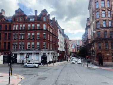 Manchester, İngiltere - 29 Eylül 2025: Manchester Whitworth Caddesi kırmızı tuğla mimarisi, yayalar ve hafif trafik ile çalkalanıyor.