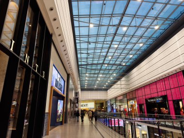 Manchester, İngiltere - 29 Eylül 2025: Bright Arndale alışveriş merkezi koridoru mağaza vitrinleri, cam çatı ve Manchester 'da perakende satışı yapan müşteriler.