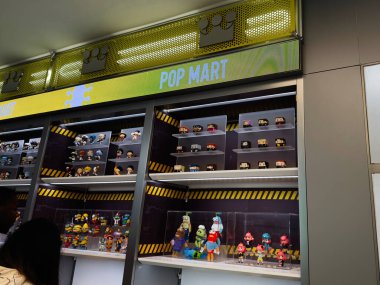 Manchester, İngiltere - 29 Eylül 2025: Manchester 'da raflarda ve cam kaplarda çeşitli heykelciklerin bulunduğu bir mağazada renkli Pop Mart oyuncak sergisi.
