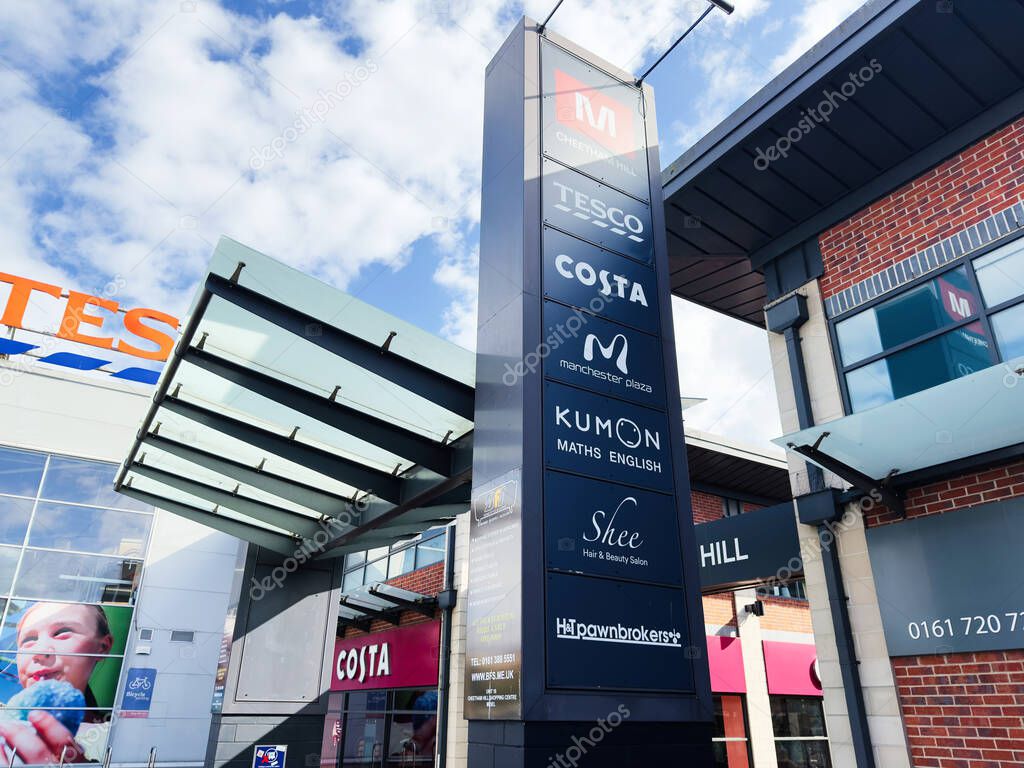 Manchester, UK - September 29, 2025: A modern The Cheetham Hill Shopping Centre mall exterior in Manchester with a tall signboard displaying multiple brand logos.