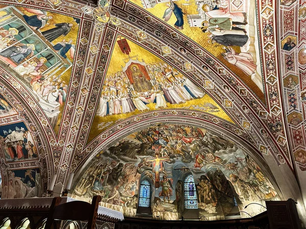 Bir Assisi kilisesinin canlı iç mekanında altın mozaikler ve kubbeli tavanlar boyunca ayrıntılı freskler bulunur..