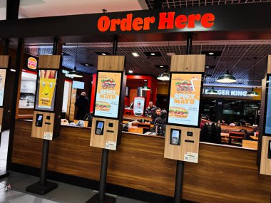 Dublin, İrlanda - 24 Ekim 2025: Meşgul lokantalar Dublin, İrlanda 'da bir fast food restoranı Burger King' de sipariş vermek için dijital büfe kullanıyorlar.