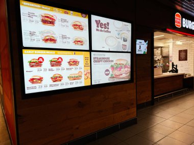 Dublin, İrlanda - 24 Ekim 2025: Parlak Burger King menüsü Dublin, İrlanda 'da modern bir fast food mağazasında hamburgerleri ve kahveyi tanıtıyor.