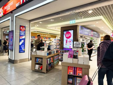 Dublin, İrlanda - 24 Ekim 2025: Dublin 'de raflara ve tanıtım tabelalarına bakan müşterilerin bulunduğu bir alışveriş merkezinde kitapçı sergisi.