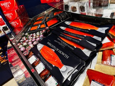 Dublin, İrlanda - 24 Ekim 2025 Dublin 'deki bir dükkanda tütsülenmiş somon paketleri ve çay kutuları.