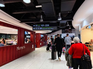 Dublin, İrlanda - 24 Ekim 2025: Dublin havaalanı yolcuları, bavullar, dükkanlar ve açık kapı işaretleriyle dolu.