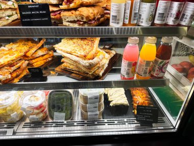 Dublin, İrlanda - 24 Ekim 2025: Bugün Dublin 'de yoğun cam vitrinler, kızarmış sandviçler, hamur işleri, yoğurtlar ve renkli içecekler.