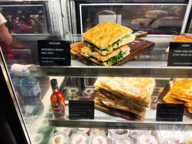 Dublin, İrlanda - 24 Ekim 2025 Dublin 'deki bir markette soğutulmuş cam kutunun içinde tahta tahtalar üzerinde taze sandviçler.