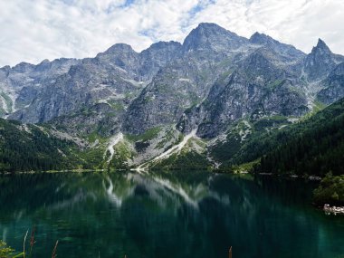 Polonya 'nın Zakopane kenti yakınlarında, çam ormanları tarafından çerçevelenmiş, sakin bir alp gölü dramatik dağları yansıtır..