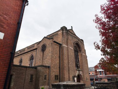 Manchester, İngiltere - 30 Eylül 2025: Manchester 'daki Tuğla Saint Alphonsus Katolik Kilisesi, Gotik kemerler, sonbahar ağaçları ve kentsel çevre.