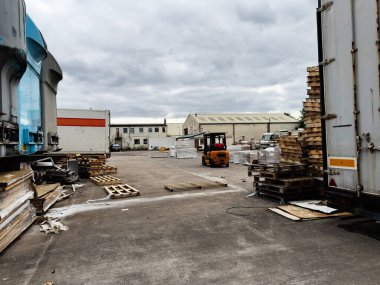 Manchester, İngiltere - 30 Eylül 2025: Manchester 'da kereste yığınları, paletler ve iş yerinde bir forklift gösteren açık hava deposu.