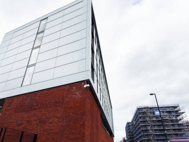 Manchester, İngiltere - 30 Eylül 2025: Manchester 'da inşaat halindeki bir caddede cam ön cepheli modern tuğla tabanı.
