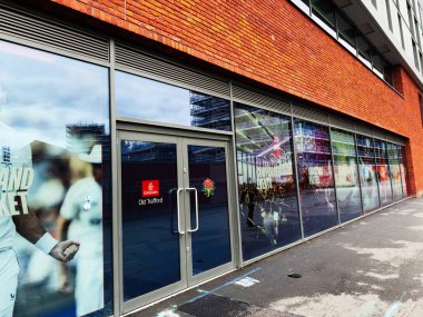 Manchester, İngiltere - 30 Eylül 2025: Manchester 'daki bir spor mağazasının cam vitrininde fan ve afişlerin yansımaları.