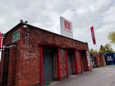 Manchester, İngiltere - 30 Eylül 2025: Manchester Old Trafford 'da tuğla bina dışı kırmızı çerçeveli ve hoş geldin işareti.