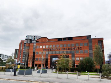 Manchester, İngiltere - 30 Eylül 2025: Manchester 'daki Üniversite Akademisi 92 üniversite kampüs binası tuğla cephe, büyük pencereler ve çevre yeşillik.